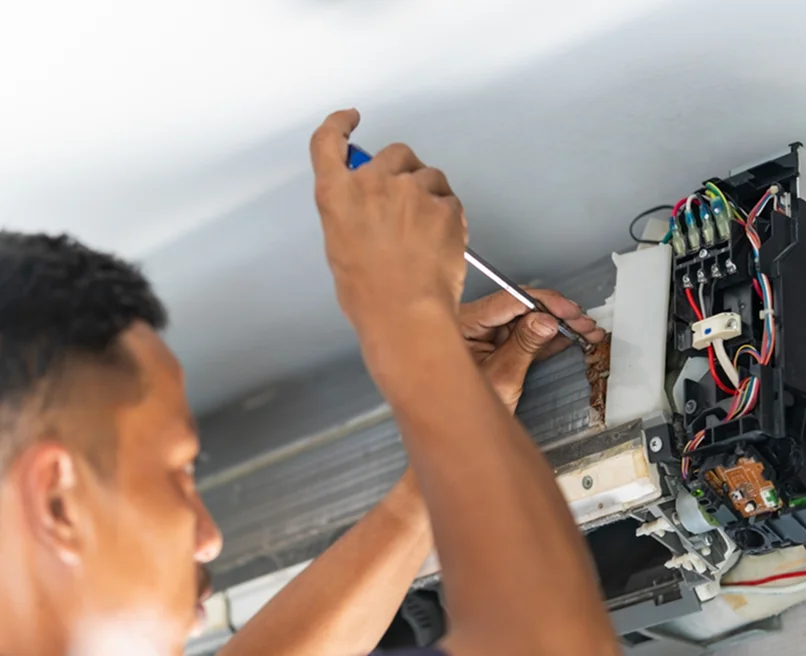 HVAC technician repairing an indoor unit, showcasing expert and reliable HVAC service in the Puget Sound area.